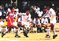 Youth team players race for the ball in a game of football.