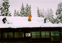 Removing snow from a rooftop to prevent the house from collapsing.