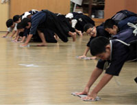 Everyone pitches in before practice, using rags to clean the dojo (training hall) floor.