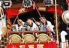 Children beat wataiko atop a float at a festival.