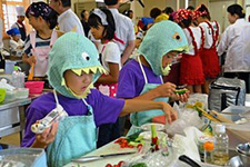 Costumed elementary school kids cooking a dinosaur-themed dish 