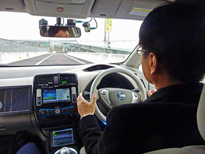 An autonomous vehicle during an experiment on a highway. The computer locates highway entrances and exits, switches on the turn indicator when it approaches its destination and heads for the exit. The developer sitting in the driving seat is not touching the steering wheel.