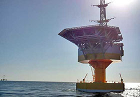 Electricity relaying marine substation. Power generating windmill can be seen in the distance.