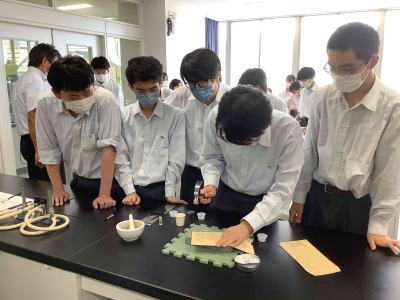 Students in a prep study session. They crush stones into powder, and then mix the powder into glue to create paint for coloring pictures.