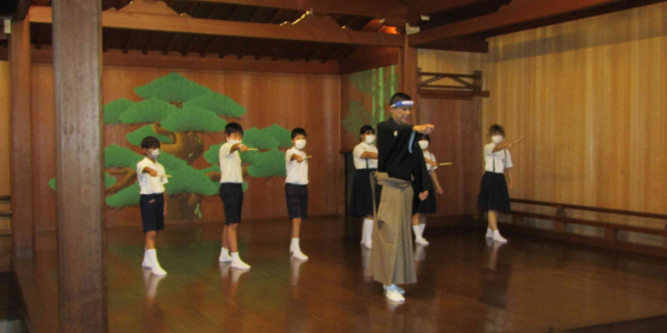 Students being taught by a Noh actor during a school trip.