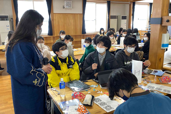 Students creating traditional patterns of the Ainu people (the indigenous people of Hokkaido) by cutting paper.