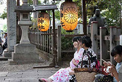 浴衣を着て神社の境内でおしゃべりをする女の子たち