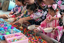 浴衣でスーパーボールすくいをする子どもたち