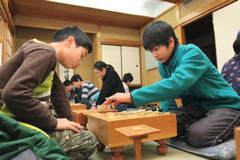 将棋盤を挟んだ真剣勝負を通じて、技と心を鍛える子どもたち（撮影協力　日本将棋連盟）