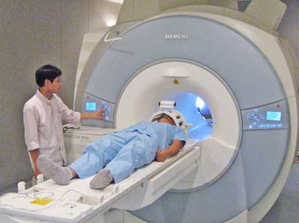 A test subject enters the fMRI machine. ©ATR