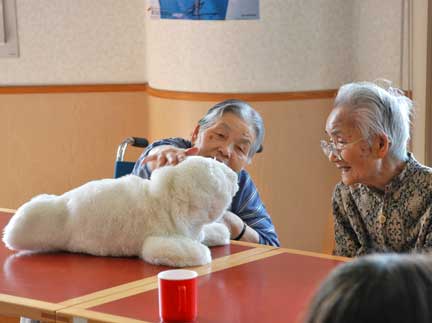 Japanese women interact with Paro. (C)AIST