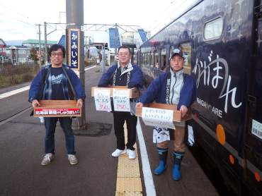 Teru Ito (far left), Chair of the "Kamiiso Station Shopping Association" stands on the platform at Kamiiso Station with other members to sell their wares. They are hoping that next time the passengers will visit their stores directly