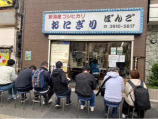 Restaurant spécialisé dans les onigiri de grande taille (entre 180 et 200 grammes). Les onigiri fraîchement préparés peuvent être consommés sur place avec notamment de la soupe miso. De nombreux clients attendent l’ouverture du magasin. La spécialité de la maison est un onigiri préparé avec du jaune d’œuf mariné dans de la sauce soja qui apporte au tout une saveur corsée.