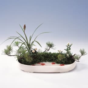 Moribana arrangements are wider and shallower, generally featuring dense, mound-like compositions and a visible water surface at the base. (Photo courtesy of OHARA SCHOOL OF IKEBANA)