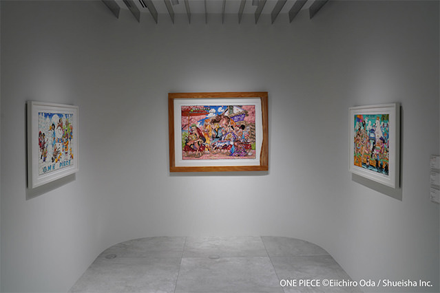 Interior view of a gallery exhibiting framed One Piece manga artworks arranged on white walls
