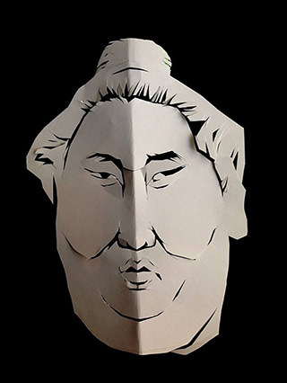 Close-up of a kirie (paper-cut) portrait depicting the face of a sumo wrestler, rendered in bold black lines on white paper.