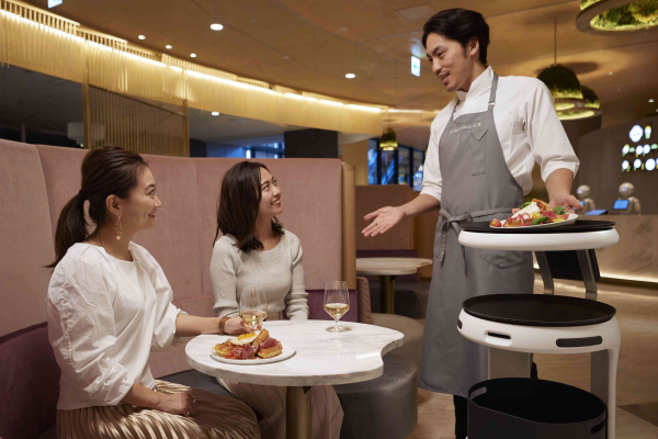 A tray delivery robot designed to work together with a human employee.