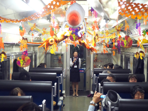 Inside the 'Nagamare Kaikyo' train Keiko Katsuta, an on-board member of the Donan Isaribi Tetsudo staff, gives passengers a guided tour of the sights along the route