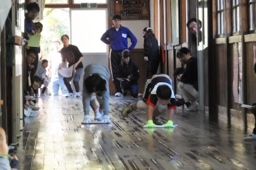 En algunas zonas de ciudad Midori, en la prefectura Gunma, se llevan a cabo carreras "<i>zokin<i>" como uno de los eventos en el Festival de los Niños cada noviembre, que se lleva a cabo utilizando los amplios pasillos de los edificios escolares de madera. Este edificio escolar está lleno de historia, se abrió en mayo de 1873, pero ahora ya no se usa (la foto de la izquierda). En la escuela de primaria Azuma de la ciudad, se llevan a cabo también carreras <i>Zokin<i> dentro de la escuela (cortesía de la Escuela Primaria Azuma, una escuela municipal de Midori)